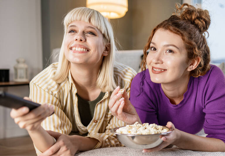 Bild zeigt zwei fröhliche Frauen beim Streamen