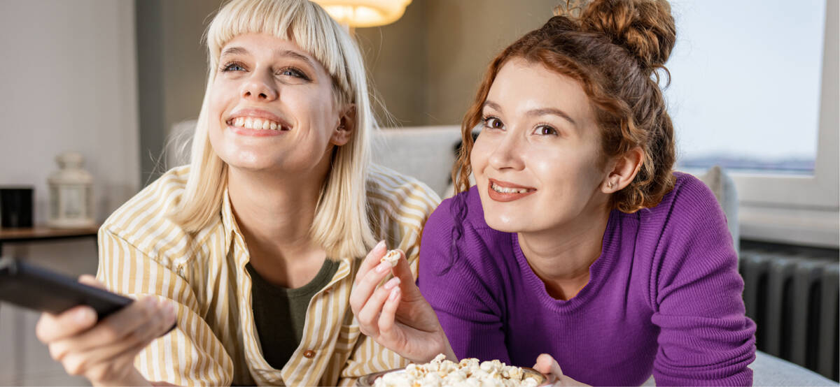 Bild zeigt zwei fröhliche Frauen beim Streamen
