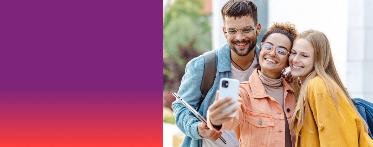 Zwei Frauen und ein Mann stehen lächelnd nebeneinander und schauen auf ihr Handy