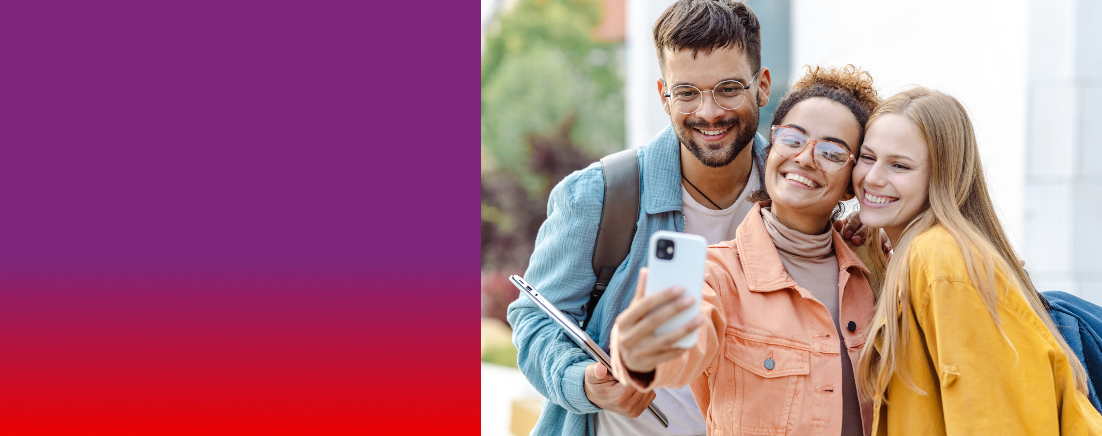 Zwei Frauen und ein Mann stehen lächelnd nebeneinander und schauen auf ihr Handy