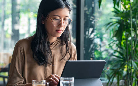 Frau sitzt vor Tablet und löscht Daten nachdem ihr Handy gestohlen wurde