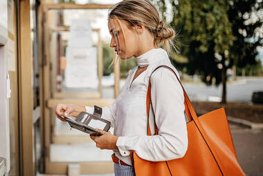 Frau auf Straße mit Geldbörse in der Hand